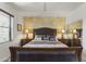 A primary bedroom featuring an upholstered headboard, bedside tables with lamps, and a textured accent wall at 5450 E Mclellan Rd # 102, Mesa, AZ 85205