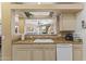 The kitchen features an eat-in bar area overlooking the living room, complete with essential appliances and sleek wooden cabinets at 5450 E Mclellan Rd # 102, Mesa, AZ 85205