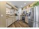 An eat-in kitchen featuring stainless steel appliances, light wooden cabinets, and a view into the living room at 5450 E Mclellan Rd # 102, Mesa, AZ 85205