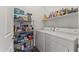 Functional laundry room with white washer and dryer, storage shelving, and cleaning supplies at 5450 E Mclellan Rd # 102, Mesa, AZ 85205