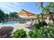 Beautiful community pool area with lounge chairs and shade structures surrounded by lush landscaping at 5450 E Mclellan Rd # 102, Mesa, AZ 85205
