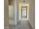 Hallway is long with white walls and concrete floors leading to sliding glass doors at the end at 5639 W Summerside Rd, Laveen, AZ 85339
