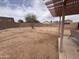 Backyard with dirt, block wall, small tree, patio, and pergola at 5684 S 237Th Dr, Buckeye, AZ 85326