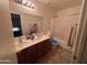 Bathroom featuring double sinks, a large mirror, and a shower with a white curtain at 5684 S 237Th Dr, Buckeye, AZ 85326