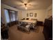 Comfortable bedroom with a patterned bedspread, soft lighting, and a window with curtains at 5684 S 237Th Dr, Buckeye, AZ 85326