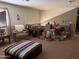 Open-concept living room with carpet, large windows, an ottoman, and an accent chair at 5684 S 237Th Dr, Buckeye, AZ 85326