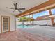 Covered back patio with brick flooring opens to a pool and patio with lounge chairs at 6704 W Topeka Dr, Glendale, AZ 85308