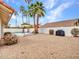 Large backyard features a built-in pool, rock ground cover, and mature palm trees at 6704 W Topeka Dr, Glendale, AZ 85308