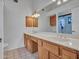 Bathroom featuring double sinks, oak cabinets, and a large mirror providing ample counter space at 6704 W Topeka Dr, Glendale, AZ 85308