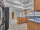 Kitchen featuring wood cabinets, sleek countertops, and a black refrigerator at 6704 W Topeka Dr, Glendale, AZ 85308