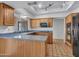 Open kitchen with wood cabinets, modern appliances, and lots of natural light at 6704 W Topeka Dr, Glendale, AZ 85308