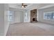 Spacious living room with neutral carpet, stone fireplace, and natural light from windows with blinds at 6704 W Topeka Dr, Glendale, AZ 85308