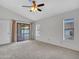 Light-filled main bedroom with a sliding door to the pool area, neutral carpet and a ceiling fan at 6704 W Topeka Dr, Glendale, AZ 85308