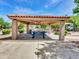 Shaded picnic area with a tiled roof, picnic table, and seating, perfect for outdoor dining at 6704 W Topeka Dr, Glendale, AZ 85308