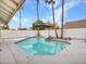Backyard pool with an umbrella, surrounded by tall palm trees at 6704 W Topeka Dr, Glendale, AZ 85308