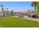Spacious backyard featuring artificial grass, a pool, an outdoor kitchen, and a shaded lounge area at 6926 E Culver St, Scottsdale, AZ 85257
