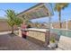 Enjoy this outdoor kitchen, with a stone surround and steel grill top, perfect for entertaining by the pool at 6926 E Culver St, Scottsdale, AZ 85257