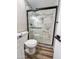 Modern bathroom with a glass-enclosed shower with pebble floor and white and marble look tile at 7316 W Carol Ave, Peoria, AZ 85345