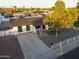 Charming single-story home with well-manicured landscaping, mature trees, and a white picket fence at 7316 W Carol Ave, Peoria, AZ 85345