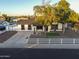 Charming single-story home with well-manicured landscaping, mature trees, and a white picket fence at 7316 W Carol Ave, Peoria, AZ 85345