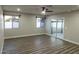 Bright, neutral living space with wood-look floors, ceiling fan, and sliding glass door to backyard patio area at 7316 W Carol Ave, Peoria, AZ 85345