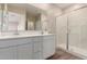 A bathroom with double sinks, white cabinets and a glass shower enclosure at 7342 E Hackamore Ln, San Tan Valley, AZ 85143