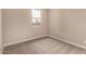A vacant bedroom with neutral carpeting and a view to the exterior at 7342 E Hackamore Ln, San Tan Valley, AZ 85143