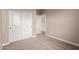 A vacant bedroom with neutral carpeting and white closet doors at 7342 E Hackamore Ln, San Tan Valley, AZ 85143