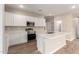 Modern kitchen features white cabinets, stainless steel appliances, quartz countertops, and a large island at 7342 E Hackamore Ln, San Tan Valley, AZ 85143