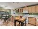Bright kitchen with wood-look flooring, light wood cabinets and white appliances at 8500 E Southern Ave # 379, Mesa, AZ 85209