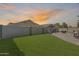 Expansive backyard with lush artificial turf, an outdoor kitchen, and a lounge area, perfect for entertaining at 854 S Del Rio Ct, Apache Junction, AZ 85120