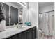 A well-lit bathroom features a large vanity with sleek gray cabinets and a shower with a world map curtain at 854 S Del Rio Ct, Apache Junction, AZ 85120