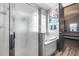 Bright bathroom showcasing a glass-enclosed shower, marble-surround tub, and stylish gray accents at 854 S Del Rio Ct, Apache Junction, AZ 85120