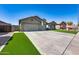 Charming home featuring a wide driveway and a manicured lawn with a desert landscape and artificial turf at 854 S Del Rio Ct, Apache Junction, AZ 85120