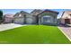 Charming single-story home with a three-car garage, stone accents, desert landscaping and lush green turf at 854 S Del Rio Ct, Apache Junction, AZ 85120
