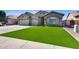 Single-Gathering home with a three-car garage, stone accents, desert landscaping and lush green turf at 854 S Del Rio Ct, Apache Junction, AZ 85120