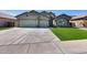 Single-story home featuring a three-car garage, desert landscaping and stone accents at 854 S Del Rio Ct, Apache Junction, AZ 85120