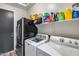 Functional laundry area showcasing modern washer, dryer, shelving, and a mini fridge for added convenience at 854 S Del Rio Ct, Apache Junction, AZ 85120
