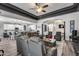 Open concept living room featuring a tray ceiling, gray leather furniture and seamless kitchen access at 854 S Del Rio Ct, Apache Junction, AZ 85120