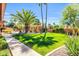 Expansive backyard with mature palm trees, lush green grass, and a charming pergola at 8935 E Larkspur Dr, Scottsdale, AZ 85260