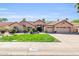 Inviting single-story home featuring lush green lawn and mature trees enhancing its curb appeal at 8935 E Larkspur Dr, Scottsdale, AZ 85260