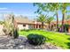Beautiful front yard with lush green grass, mature palm trees, and attractive desert landscaping at 8935 E Larkspur Dr, Scottsdale, AZ 85260