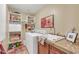 Well-organized laundry room featuring built-in shelving, a washing machine, and granite countertops at 8935 E Larkspur Dr, Scottsdale, AZ 85260