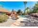Relaxing backyard pool area featuring chaise lounges, mature landscaping, and a charming desert setting at 8935 E Larkspur Dr, Scottsdale, AZ 85260