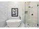 Modern bathroom featuring a soaking tub, glass shower, and marble tile walls at 9270 E Thompson Peak Pkwy # 381, Scottsdale, AZ 85255
