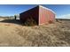 Spacious exterior with a large metal building surrounded by desert landscape and a clear blue sky at 9600 S 393Rd Ave, Tonopah, AZ 85354