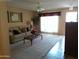 Comfortable living room with neutral colors, plush carpet, and ample natural light at 10327 W Prairie Hills Cir, Sun City, AZ 85351