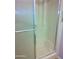 Clean shower featuring a tub with sliding glass door and textured walls at 10327 W Prairie Hills Cir, Sun City, AZ 85351