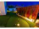 Backyard putting green with well-maintained turf, ambient lighting, and decorative fencing, adding a fun recreational element at 10640 E Mercer Ln, Scottsdale, AZ 85259