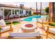 Backyard pool area featuring outdoor seating, a modern fire pit, manicured lawn, and several lounge chairs at 10640 E Mercer Ln, Scottsdale, AZ 85259